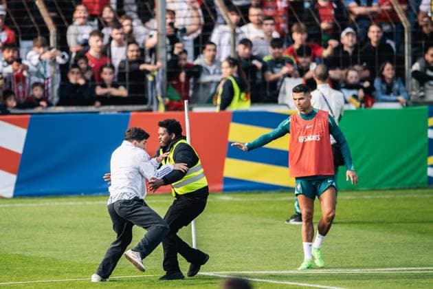 Portugal Public Training Session And press conference, PK, Pressekonferenz - UEFA EURO, EM, Europameisterschaft,Fussball 2024 A security man is chasing a fan after the fan storms the pitch to take a photo with Cristiano Ronaldo during the public training session of Portugal ahead of the UEFA EURO 2024 in Gutersloh, Germany, on June 14, 2024. Gutersloh Germany  Copyright: xHeshamxElsherifx originalFilename:elsherif-notitle240614_np0QZ.jpg