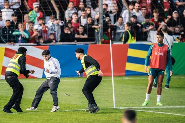 Portugal Public Training Session And press conference, PK, Pressekonferenz - UEFA EURO, EM, Europameisterschaft,Fussball 2024 A security man is chasing a fan after the fan storms the pitch to take a photo with Cristiano Ronaldo during the public training session of Portugal ahead of the UEFA EURO 2024 in Gutersloh, Germany, on June 14, 2024. Gutersloh Germany  Copyright: xHeshamxElsherifx originalFilename:elsherif-notitle240614_npYMf.jpg