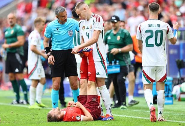 Attila Szalai of Hungary stretches the legs of Silvan Widmer of Switzerland as he goes down with cramp during play Hungary v Switzerland, UEFA European Championship, EM, Europameisterschaft 2024, Group A, Football, Cologne Stadium, Cologne, Germany, 15 Jun 2024 EDITORIAL USE ONLY No use with unauthorised audio, video, data, fixture lists, club league logos or live services. Online in-match use limited to 120 images, no video emulation. No use in betting, games or single club league player publications.  Copyright: xMichaelxZemanek Shutterstockx 14539265bt