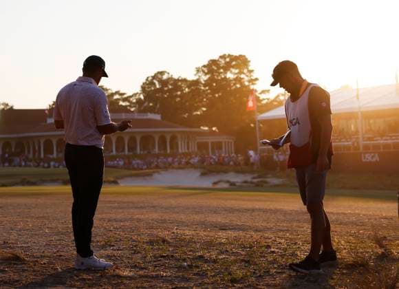Bryson DeChambeau and caddie Gregory Bodine wait before hitting the second shot to the eighteenth green during the third round of the 124th U.S. Open golf championship at Pinehurst Resort & Country Club in Pinehurst, N.C. on Saturday, June 15, 2024. DeChambeau finished the day in the lead at 7-under-par.  NCP20240615401 JOHNxANGELILLO