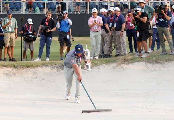 Bryson DeChambeau smooths the sand in a bunker as he celebrates after winning the 124th U.S. Open golf championship at Pinehurst Resort & Country Club in Pinehurst, N.C. on Sunday, June 16, 2024. DeChambeau won with a six-under-par score of 274.  NCP20240616680 JOHNxANGELILLO