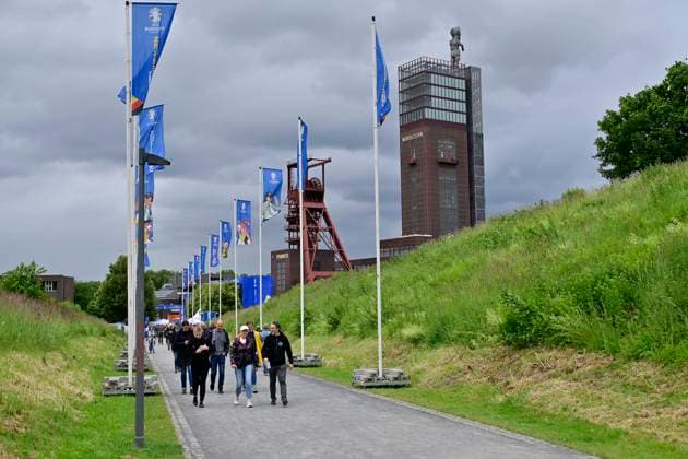 15.06.2024, Deutschland, Nordrhein-Westfalen, Ruhrgebiet, Gelsenkirchen. Fussball Europameisterschaft 2024. Gelsenkirchen feiert mit vier Spielen der UEFA EURO, EM, Europameisterschaft,Fussball 2024 ein grosses Fussballfest. In der Fan Zone mit Public Viewing im Nordsternpark Gelsenkirchen und im Amphitheater werden alle Spiele, die in Gelsenkirchen ausgetragen werden, sowie alle Spiele der duetschen Nationalmannschaft live uebertragen. In der Fan Zone auf dem Nordsternplatz und im Amphitheater ist Platz fuer jeweils 6.000 Besucher innen. Blick auf die Fanmeile zum Nordsternplatz. Fussball EM 2024 Fan Zone und Public Viewing im Nordsternpark Gelsenkirchen