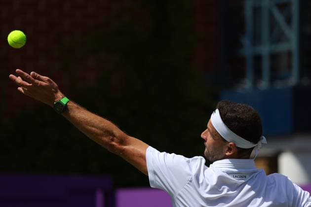 17th June 2024; Cinch Championships, Queens Club, West Kensington, London, England: Cinch Championships Queens Club, Day 1; Grigor Dimitrov (BUL) wearing his Lacoste polo shirt and headband serves to Adrian Mannarino (FRA) mens singles  ActionPlus12655623 JohnxPatrickxFletcher