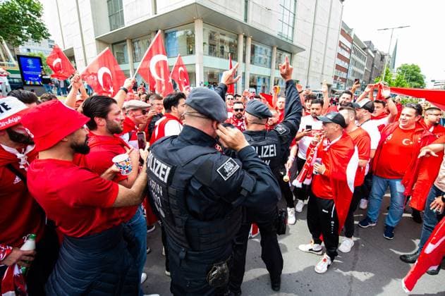 18 06 2024 Football, European Championship 2024 in Germany, fans in Dortmund Turkey Georgia Turkish fans with police officers at lunchtime before the match in the city center A police officer celebrates briefly with