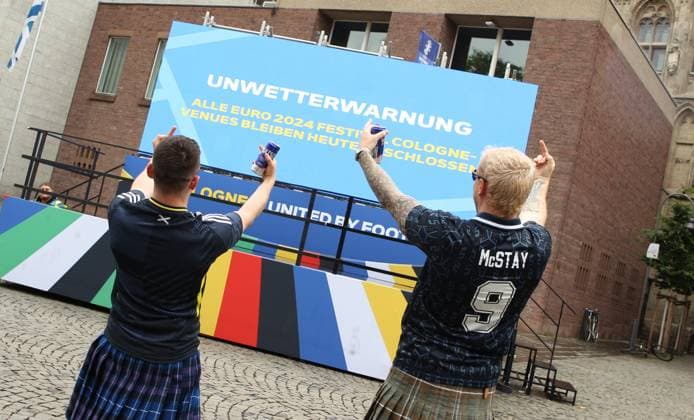 On a digital information board, the city of Cologne announces that the Euro 2024 fan festival will remain closed on Tuesday due to a severe weather warning These two fans of the Scottish national soccer team wont let it spoil their fun Cologne North Rhine-Westphalia