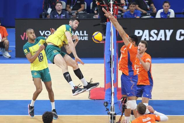 PH: Brazil Outlasts Netherlands in Four Sets during VNL 2024 Match Flavio Resende Gualberto 23, Yellow of Brasil spikes the ball towards two players of Netherlands. Pasay City Metro Manila Philippines Copyright: DennisxJeromexAcosta