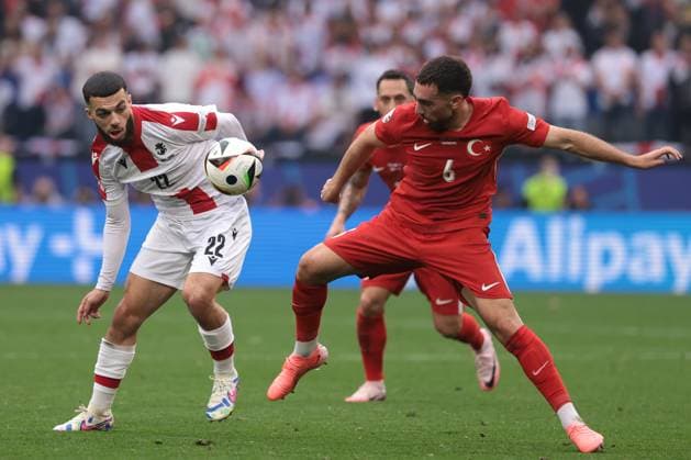 Dortmund, Germany, 18th June 2024. Hakan Calhanoglu of Turkey looks on as team mate Orkun Kokcu battles for possession with Georges Mikautadze of Georgia during the UEFA European Championships match at BVB Stadion, Dortmund. Picture credit should read: Jonathan Moscrop Sportimage EDITORIAL USE ONLY. No use with unauthorised audio, video, data, fixture lists, club league logos or live services. Online in-match use limited to 120 images, no video emulation. No use in betting, games or single club league player publications. SPI-3185-0044