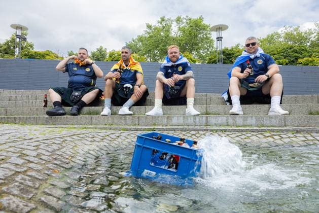 EM24 fan in Cologne, Scotland vs Switzerland Germany, Cologne on 19 06 2024 Scottish football fans cool the beer crate in a sprinkling fountain in the city center of Cologne