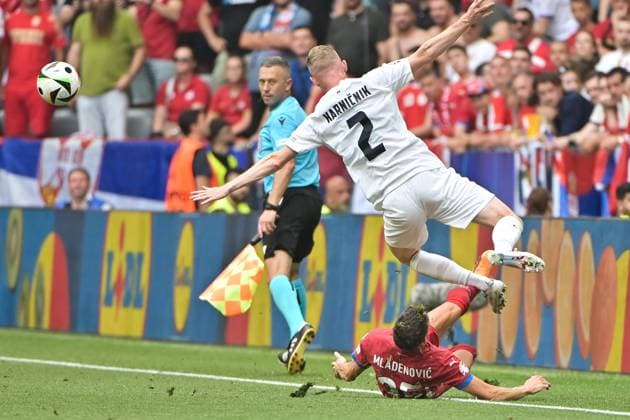 Picture shows from left to right Filip Mladenovic 25, Serbia with straddle against Zan Karnicnik 2, Slovenia , 20 06 2024, Munich, Soccer, European Championship, Slovenia Serbia, EVENT REGULATIONS PROHIBIT ANY USE OF PHOTOGRAPHS AS IMAGE SEQUENCES AND OR QUASI VIDEO xklx