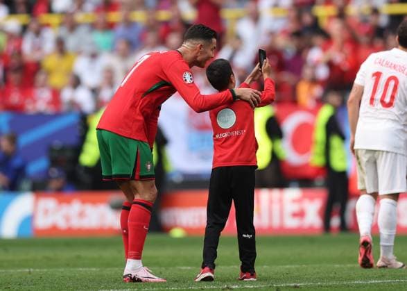 Dortmund, Germany, 22nd June 2024. A young fan runs onto the pitch for a selfie with Cristiano Ronaldo of Portugal before being chased by stewards during the UEFA European Championships match at BVB Stadion, Dortmund. Picture credit should read: David Klein Sportimage EDITORIAL USE ONLY. No use with unauthorised audio, video, data, fixture lists, club league logos or live services. Online in-match use limited to 120 images, no video emulation. No use in betting, games or single club league player publications. SPI-3202-0086