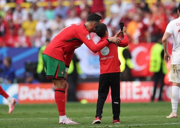 Sport Bilder des Tages Dortmund, Germany, 22nd June 2024. A young fan runs onto the pitch for a selfie with Cristiano Ronaldo of Portugal before being chased by stewards during the UEFA European Championships match at BVB Stadion, Dortmund. Picture credit should read: David Klein Sportimage EDITORIAL USE ONLY. No use with unauthorised audio, video, data, fixture lists, club league logos or live services. Online in-match use limited to 120 images, no video emulation. No use in betting, games or single club league player publications. SPI-3202-0087