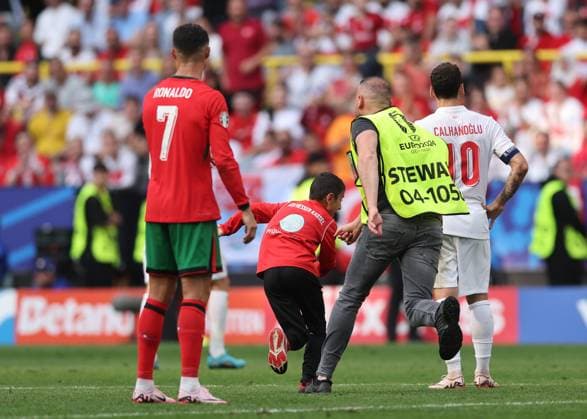 Dortmund, Germany, 22nd June 2024. A young fan runs onto the pitch for a selfie with Cristiano Ronaldo of Portugal before being chased by stewards during the UEFA European Championships match at BVB Stadion, Dortmund. Picture credit should read: David Klein Sportimage EDITORIAL USE ONLY. No use with unauthorised audio, video, data, fixture lists, club league logos or live services. Online in-match use limited to 120 images, no video emulation. No use in betting, games or single club league player publications. SPI-3202-0092