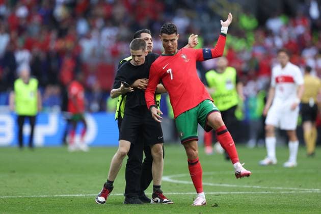 A fan enters the pitch during the match and grabs Cristiano Ronaldo of Portugal Turkiye v Portugal, UEFA European Championship, EM, Europameisterschaft 2024, Group F, Football, BVB Stadion, Dortmund, Germany, 22 Jun 2024 EDITORIAL USE ONLY No use with unauthorised audio, video, data, fixture lists, club league logos or live services. Online in-match use limited to 120 images, no video emulation. No use in betting, games or single club league player publications.  Copyright: xPaulxCurrie Shutterstockx 14548034et