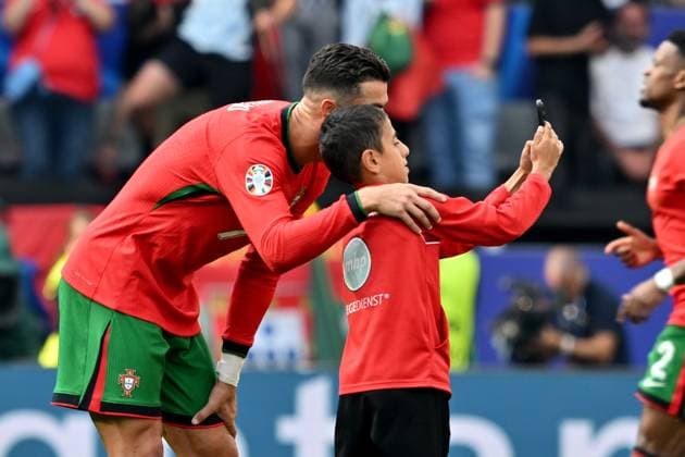 22 06 2024, xsltx, Football EM 2024, Turkey Portugal emspor, v l A little boy takes a selfie with Cristiano Ronaldo Portugal on the field and is then captured by stewards Cell phone, smartphone, streaker, child DFL DFB REGULATIONS PROHIBIT ANY USE OF PHOTOGRAPHS as IMAGE SEQUENCES and or QUASI VIDEO Dortmund