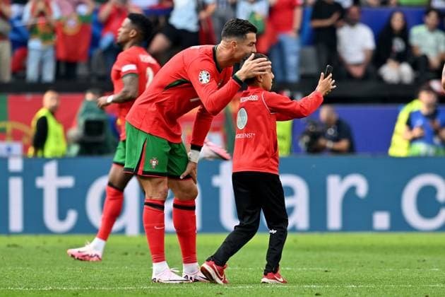 22 06 2024, xsltx, Football EM 2024, Turkey Portugal emspor, v l A little boy takes a selfie with Cristiano Ronaldo Portugal on the field and is then captured by stewards Cell phone, smartphone, streaker, child DFL DFB REGULATIONS PROHIBIT ANY USE OF PHOTOGRAPHS as IMAGE SEQUENCES and or QUASI VIDEO Dortmund