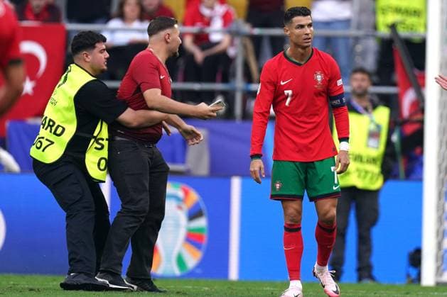 2024-06-22 Turkiye v Portugal - Group F - UEFA EURO, EM, Europameisterschaft,Fussball 2024 DORTMUND, GERMANY - JUNE 22: Cristiano Ronaldo of Portugal with pitch invader during the Group F - UEFA EURO 2024 match between Turkiye and Portugal at BVB Stadion Dortmund on June 22, 2024 in Dortmund, Germany. (Photo by Joris Verwijst BSR Agency) Dortmund Germany Content not available for redistribution in The Netherlands directly or indirectly through any third parties. Copyright: xBSRxAgencyx