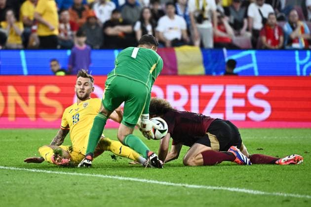 240622 EURO2024 BELGIUM VS ROMANIA Denis DraguÅü (19) of Romania battles for the ball with Wout Faes (4) of Belgium and Koen Casteels (1) of Belgium during a soccer game between the national teams of Belgium, called the Red Devils and Romania on the second matchday in Group E in the group stage of the UEFA EURO, EM, Europameisterschaft,Fussball 2024 tournament , on Saturday 22 June 2024 in Cologne , Germany . PHOTO Isosport Maarten Straetemans Cologne GERMANY  Copyright: xx 466931