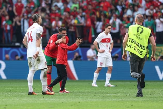 (240623) -- DORTMUND, June 23, 2024 -- A pitch invader takes a selfie with Cristiano Ronaldo (2nd L) of Portugal during the UEFA EURO, EM, Europameisterschaft,Fussball 2024 Group F match between Portugal and Turkiye in Dortmund, Germany on June 22, 2024. ) (SP)GERMANY-DORTMUND-FOOTBALL-EURO 2024-PORTUGAL VS T?RKIYE PanxYulong 