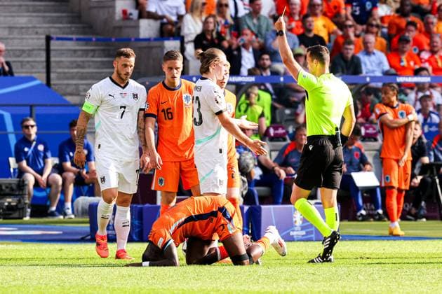 2024-06-25 Netherlands v Austria - Group D - UEFA EURO, EM, Europameisterschaft,Fussball 2024 BERLIN, GERMANY - JUNE 25: Marko Arnautovic of Austria, Joey Veerman of the Netherlands, Referee Ivan Kruzliak shows a yellow card to Patrick Wimmer of Austria, Lutsharel Geertruida of the Netherlands injured during the Group D - UEFA EURO 2024 match between Netherlands and Austria at Olympiastadion on June 25, 2024 in Berlin, Germany. (Photo by Peter Lous BSR Agency) Berlin Germany Content not available for redistribution in The Netherlands directly or indirectly through any third parties. Copyright: xBSRxAgencyx