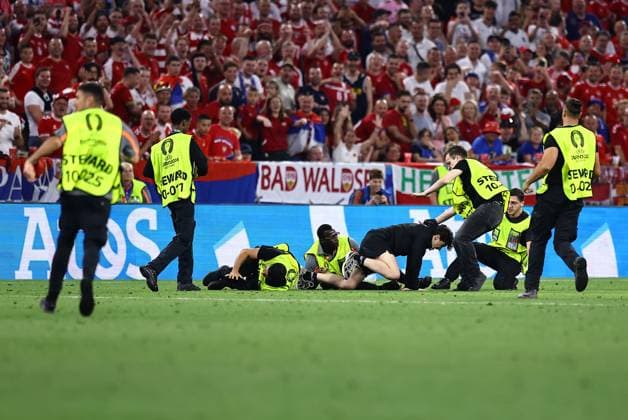 Sport Bilder des Tages Stewards tackle a pitch invader Denmark v Serbia, UEFA European Championship, EM, Europameisterschaft 2024, Group C, Football, Munich Football Arena, Munich, Germany, 25 Jun 2024 EDITORIAL USE ONLY No use with unauthorised audio, video, data, fixture lists, club league logos or live services. Online in-match use limited to 120 images, no video emulation. No use in betting, games or single club league player publications. Copyright: xMichaelxZemanek Shutterstockx 14555536cs