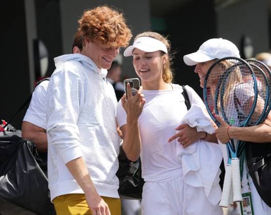 Tennis - 2024 Wimbledon Championships Training practice Yannick Sinner (Italy) with girlfriend, Anna Kalinskaya share a joke on her mobile after training 