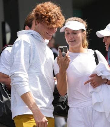 Tennis - 2024 Wimbledon Championships Training practice Yannick Sinner (Italy) with girlfriend, Anna Kalinskaya share a joke on her mobile after training 