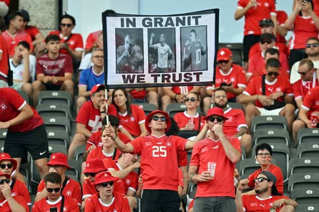 290624 KAI SCHWOERER Switzerland fans hold a sign saying ˜In Granit we trust™ to show their support for captain Granit Xhaka of Switzerland prior to the UEFA EURO, EM, Europameisterschaft,Fussball 2024 round of 16 match between Switzerland and Italy at Olympiastadion on June 29, 2024 in Berlin, Germany. 290624-CPL-SUIvITA-001