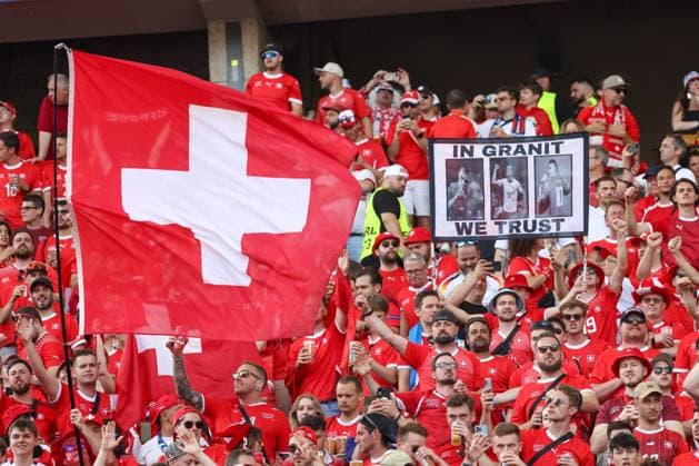 Swiss fan block, large Swiss flag, fans dressed in red, Berlin, UEFA EURO 2024, cheering crowd, enthusiastic supporters, In Granit We Trust banner, seats filled, security service, summer, festive atmosphere, fans in red, soccer enthusiasm, spectator stand, sporting event, national team, fan posters, stadium, passion, football, UEFA, European Championship, round of 16 2024, Switzerland vs Italy, 29 06 2024, Olympiastadion Berlin, Berlin, Germany Berlin Olympiastadion Berlin Berlin Germany Copyright: xGrantxHubbsx