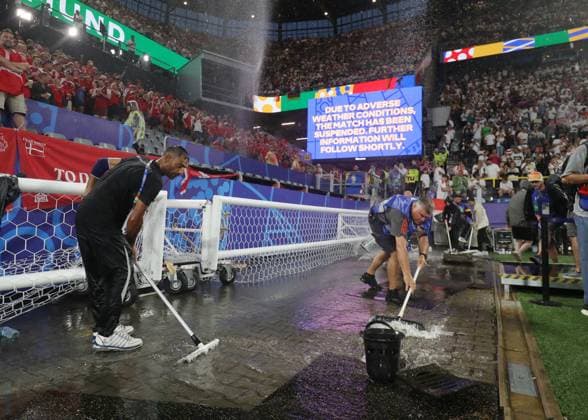Dortmund, Germany, 29th June 2024. Ground staff clear the area around the pitch following a thunderstorm which caused the suspension of play during the UEFA European Championships Group 16 match at the BVB Stadion, Dortmund. Picture credit should read: Paul Terry Sportimage EDITORIAL USE ONLY. No use with unauthorised audio, video, data, fixture lists, club league logos or live services. Online in-match use limited to 120 images, no video emulation. No use in betting, games or single club league player publications. SPI-3213-0042