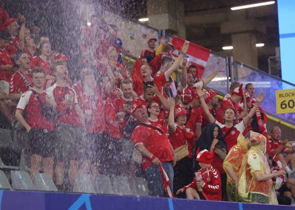 Dortmund, Germany, 29th June 2024. Denmark fans enjoy the downpour which led to the suspension of the game during the UEFA European Championships Group 16 match at the BVB Stadion, Dortmund. Picture credit should read: Paul Terry Sportimage EDITORIAL USE ONLY. No use with unauthorised audio, video, data, fixture lists, club league logos or live services. Online in-match use limited to 120 images, no video emulation. No use in betting, games or single club league player publications. SPI-3213-0047