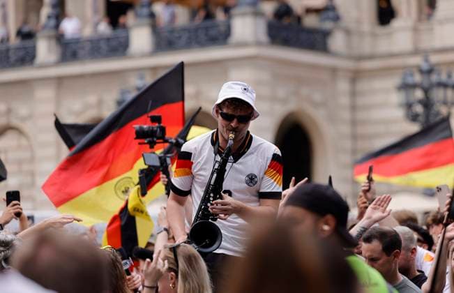 Germany Hesse Frankfurt am Main 23 06 2024 European Football Championship 2024 European Championship type with the saxophone, saxophonist in Völler jersey, Andre Schnura with the black saxophone Sport Public Viewing in Frankfurt