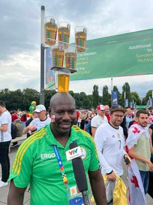Sport Themen der Woche KW26 Sport Bilder des Tages Volunteer begeistert ausländische Videoteams mit seiner Bierbecherjonglage auf dem Kopf - Köln 30.06.2024: Spanien vs. Georgien, EURO2024 M37, Achtelfinale, EM-Arena Köln *** Volunteer wows foreign video teams with his beer cup juggling on his head Cologne 30 06 2024 Spain vs Georgia, EURO2024 M37, round of 16, EM Arena Cologne