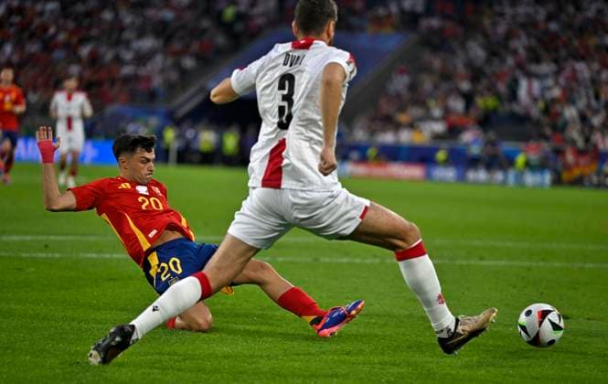 30 06 2024, Football UEFA EURO 2024, Round of 16, Spain Georgia, at Cologne Stadium, v l Pedri Spain with full commitment against Lasha Dvali Georgia