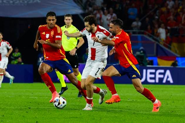 Spain s Dani Carvajal (R) and Rodri (L) in action against Georgia s Khvicha Kvaratskhelia (C) during the Euro2024 round of 16 soccer match between Spain and Georgia at RheinEnergieStadion in Cologne, Germany, 30 June 2024. Spain vs. Georgia !ACHTUNG: NUR REDAKTIONELLE NUTZUNG!  Copyright: xJJxGuillenx GRAF9960 20240630-55014023757_1
