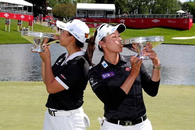 MIDLAND, MI - JUNE 30: From left to right LPGA, Golf Damen golfers Ruoning Yin and Atthaya Thitikul kiss their trophies after winning the LPGA Dow Championship on June 30, 2024, at Midland Country Club in Midland, Michigan. (Photo by Brian Spurlock Icon Sportswire) GOLF: JUN 30 LPGA Dow Championship EDITORIAL USE ONLY Icon24063033