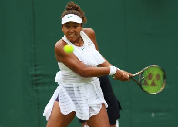 Japan s Naomi Osaka plays a backhand in her first round match against France s Diane Parry on day one of the 2024 Wimbledon Championships in London on Monday, July 01, 2024.  LON2024070141 HUGOxPHILPOTT