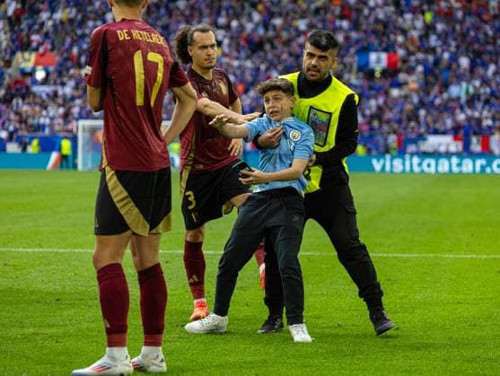 Football - UEFA EURO, EM, Europameisterschaft,Fussball 2024 - Round of 16 - France v Belgium DÜSSELDORF, GERMANY - Monday, July 1, 2024: A Belgium supporter is manhandled by a steward after running onto the pitch, as Belgium players stand by, after the UEFA Euro 2024 Round of 16 match between France and Belgium at the Düsseldorf Arena. France won 1-0. (Photo by David Rawcliffe Propaganda) DÜSSELDORF Düsseldorf Arena NORTH RHINE-WESTPHALIA GERMANY  Copyright: xDavidxRawcliffex P2024-07-01-France_Belgium-56