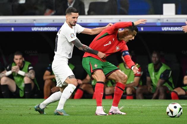 01 07 2024, xjhx, Football EM 2024 1 8 Final, Portugal Slovenia emspor, v l Petar Stojanovic Slovenia Cristiano Ronaldo Portugal duel, action, action, battle for the ball UEFA REGULATIONS PROHIBIT ANY USE OF PHOTOGRAPHS as IMAGE SEQUENCES and or QUASI VIDEO Frankfurt am Main