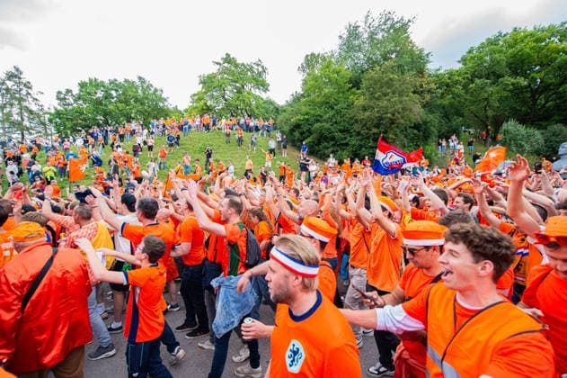 02 07 2024 Football, European Championship 2024 in Germany, fans in Munich Romania Netherlands Dutch fans before the game at the fan march near the Olympic Park Passers-by look down on the fan march from a hill
