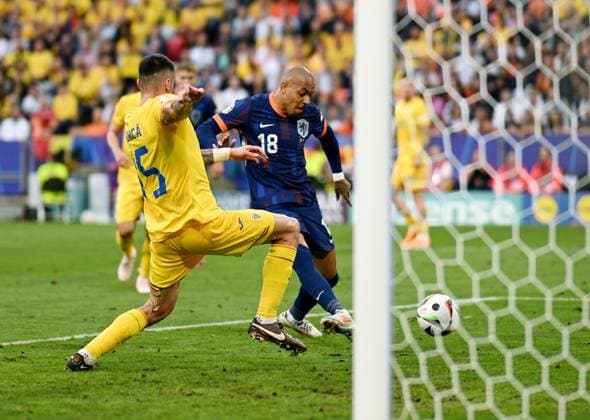 Germany Soccer Euro 2024 Romania - Netherlands 8721344 02.07.2024 Romania s Andrei Burca, let, and Netherlands Donyell Malen struggle for a ball during the UEFA EURO, EM, Europameisterschaft,Fussball 2024 round of 16 soccer match between Romania and Netherlands at the Munich Football Arena in Munich, Germany. Alexey Filippov Sputnik Munich Germany  Copyright: xAlexeyxFilippovx