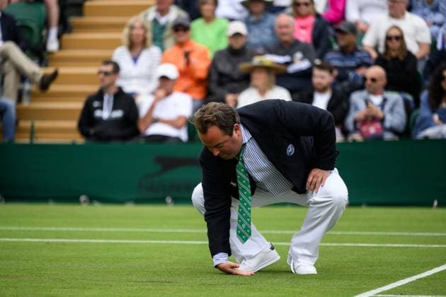 240702 An umpire checks the grass for moisture during day 2 of Wimbledon on July 2, 2024 in London Photo Jesper Zerman BILDBYRAN kod JZ JZ0548 tennis wimbledon AELTC day 2 bbeng  Copyright: JESPERxZERMAN BB240702JZ125