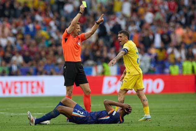 (240703) -- MUNICH, July 3, 2024 -- Referee Felix Zwayer (L) shows a yellow card to Nicolae Claudiu Stanciu (R) of Romania during the UEFA EURO, EM, Europameisterschaft,Fussball 2024 Round of 16 match between Romania and the Netherlands in Munich, Germany on July 2, 2024. ) (SP)GERMANY-MUNICH-FOOTBALL-EURO 2024-ROMANIA VS NETHERLANDS MengxDingbo 