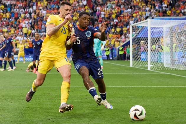 (240703) -- MUNICH, July 3, 2024 -- Steven Bergwijn (R) of the Netherlands vies with Andonie Andrei Burca of Romania during the UEFA EURO, EM, Europameisterschaft,Fussball 2024 Round of 16 match between Romania and the Netherlands in Munich, Germany on July 2, 2024. ) (SP)GERMANY-MUNICH-FOOTBALL-EURO 2024-ROMANIA VS NETHERLANDS MengxDingbo 