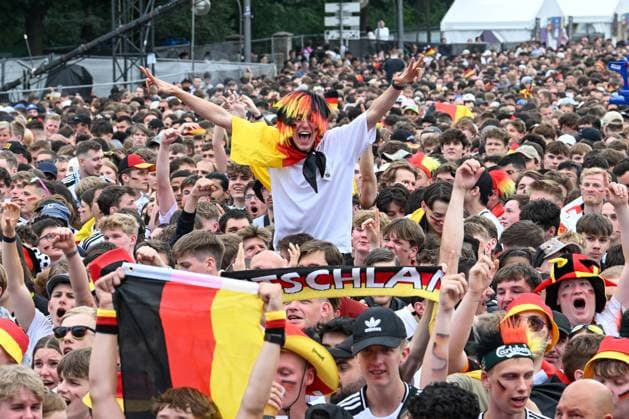 Berlin, Germany July 5, 2024 European Football Championship 2024 quarter-final Spain vs. Germany In the picture Cheering fans in the fan zone Brandenburger Tor with German flags, a male fan stretches his arms upwards Copyright: xFotostandx xReuhlx