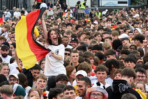 Berlin, Germany July 5, 2024 European Football Championship 2024 Quarterfinal Spain vs. Germany In the picture Cheering fans in the Brandenburger Tor fan zone, a female fan laughing and waving a German flag Germany flag Copyright: xFotostandx xReuhlx
