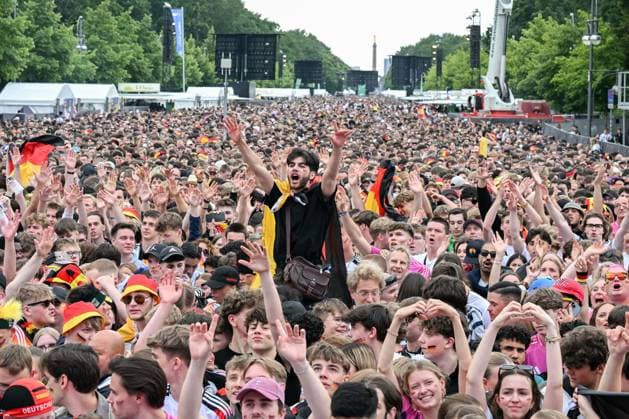 Berlin, Germany July 5, 2024 European Football Championship 2024 quarter-final Spain vs. Germany In the picture Cheering fans in the fan zone Brandenburger Tor with German flags, a male fan stretches his arms upwards Copyright: xFotostandx xReuhlx