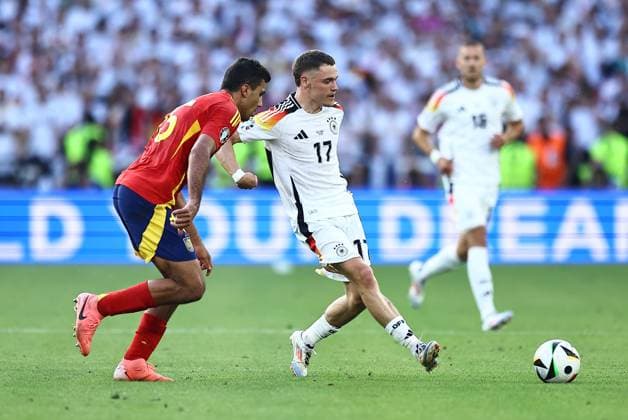 Florian Wirtz of Germany passes the ball whilst under pressure from Rodri of Spain Spain v Germany, UEFA European Championship, EM, Europameisterschaft 2024, Quarter Final, Football, Stuttgart Arena, Stuttgart, Germany, 05 Jul 2024 EDITORIAL USE ONLY No use with unauthorised audio, video, data, fixture lists, club league logos or live services. Online in-match use limited to 120 images, no video emulation. No use in betting, games or single club league player publications. Copyright: xMichaelxZemanek Shutterstockx 14571380cs