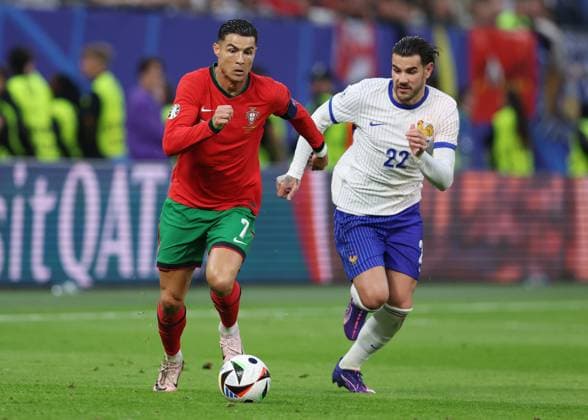 Hamburg, Germany, 5th July 2024. Cristiano Ronaldo of Portugal tussles with Theo Hernandez of France during the UEFA European Championships Quarter Final match at Volksparkstadion, Hamburg. Picture credit should read: Paul Terry Sportimage EDITORIAL USE ONLY. No use with unauthorised audio, video, data, fixture lists, club league logos or live services. Online in-match use limited to 120 images, no video emulation. No use in betting, games or single club league player publications. SPI-3217-0032