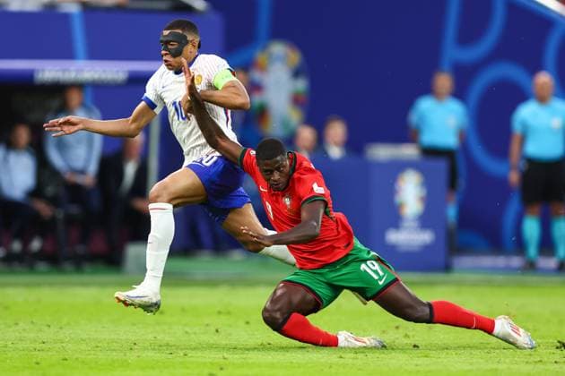 Portugal gegen Frankreich 5. Juli 2024, Hamburg UEFA EUROs Viertelfinale Portugal gegen Frankreich Kylian Mbappe (Frankreich) mit einem Gesichtsschutz und Nuno Mendes (Portugal) Foto Charlotte Wilson Abseits Hamburg Deutschland  Copyright: xCharlottexWilsonx xOffsidexOffside