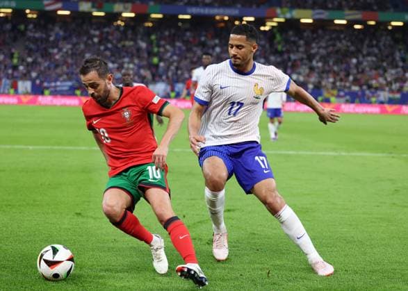Hamburg, Germany, 5th July 2024. Bernardo Silva of Portugal tussles with William Saliba of France during the UEFA European Championships Quarter Final match at Volksparkstadion, Hamburg. Picture credit should read: Paul Terry Sportimage EDITORIAL USE ONLY. No use with unauthorised audio, video, data, fixture lists, club league logos or live services. Online in-match use limited to 120 images, no video emulation. No use in betting, games or single club league player publications. SPI-3217-0035